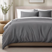 Bed with sateen bedding and pillows in a bedroom setting