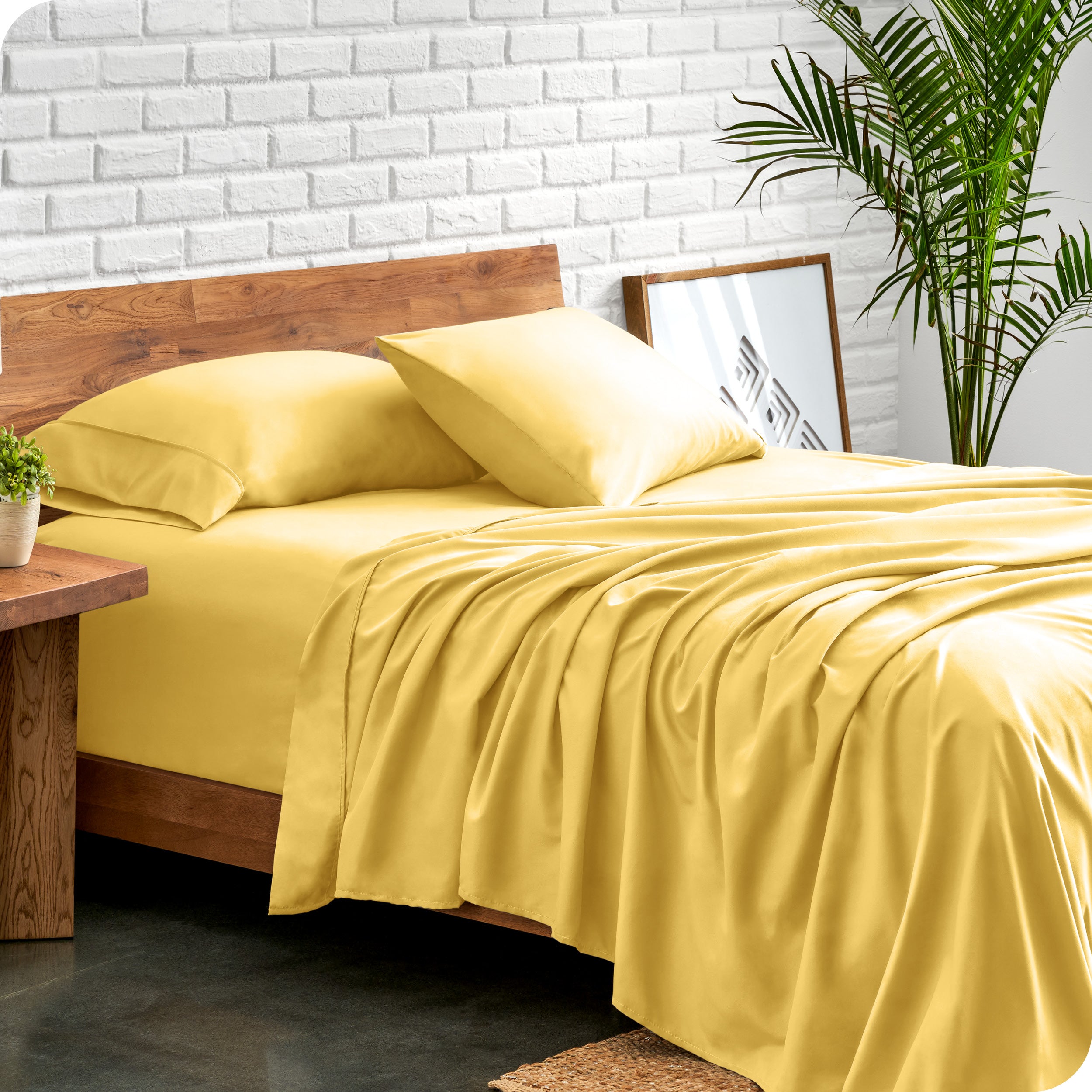 Bed with microfiber sheets against a white brick wall