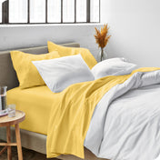 Sheets and a duvet cover on a bed in a bright bedroom