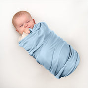 Baby wrapped in flannel receiving blanket
