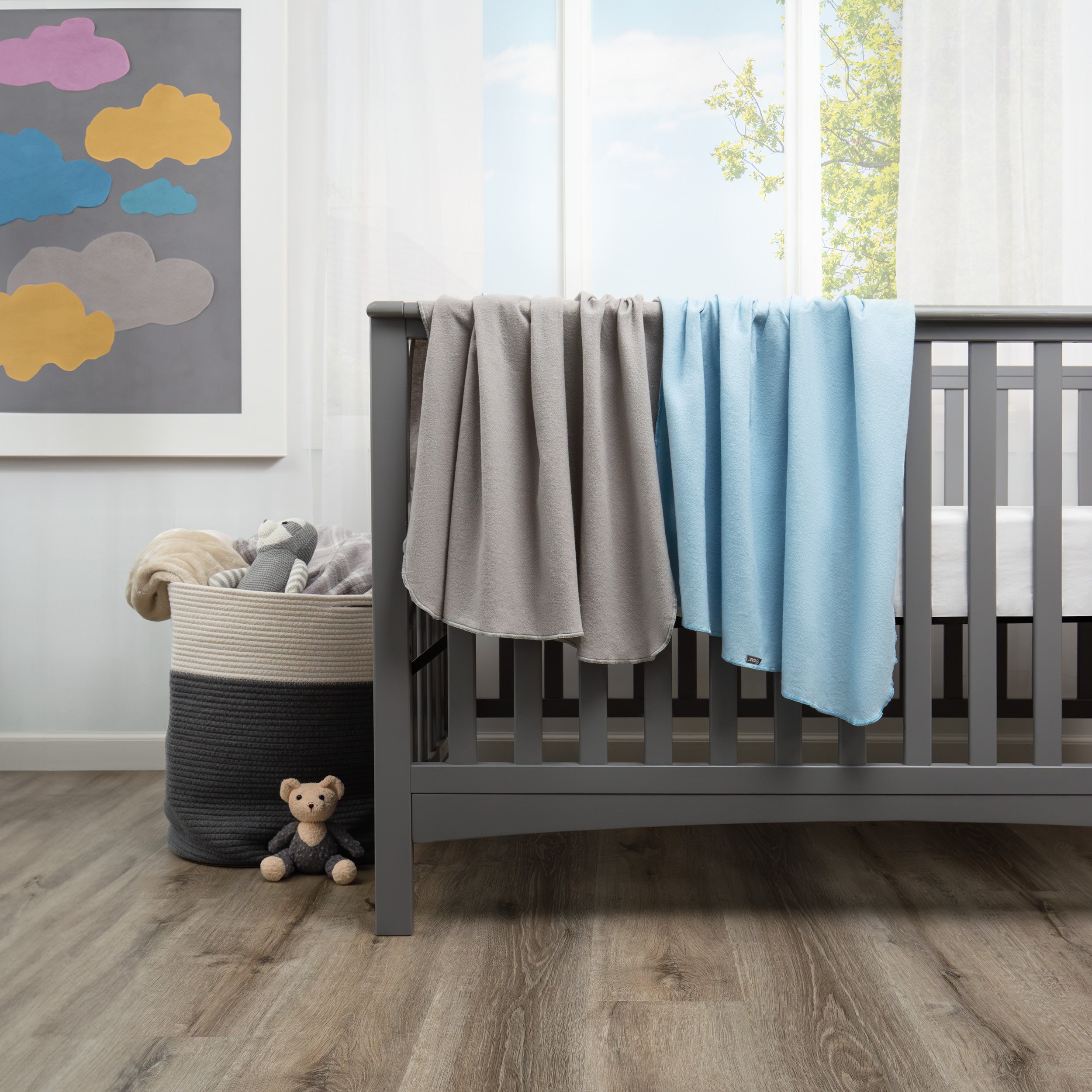 flannel receiving blanket light grey and light blue draped over crib