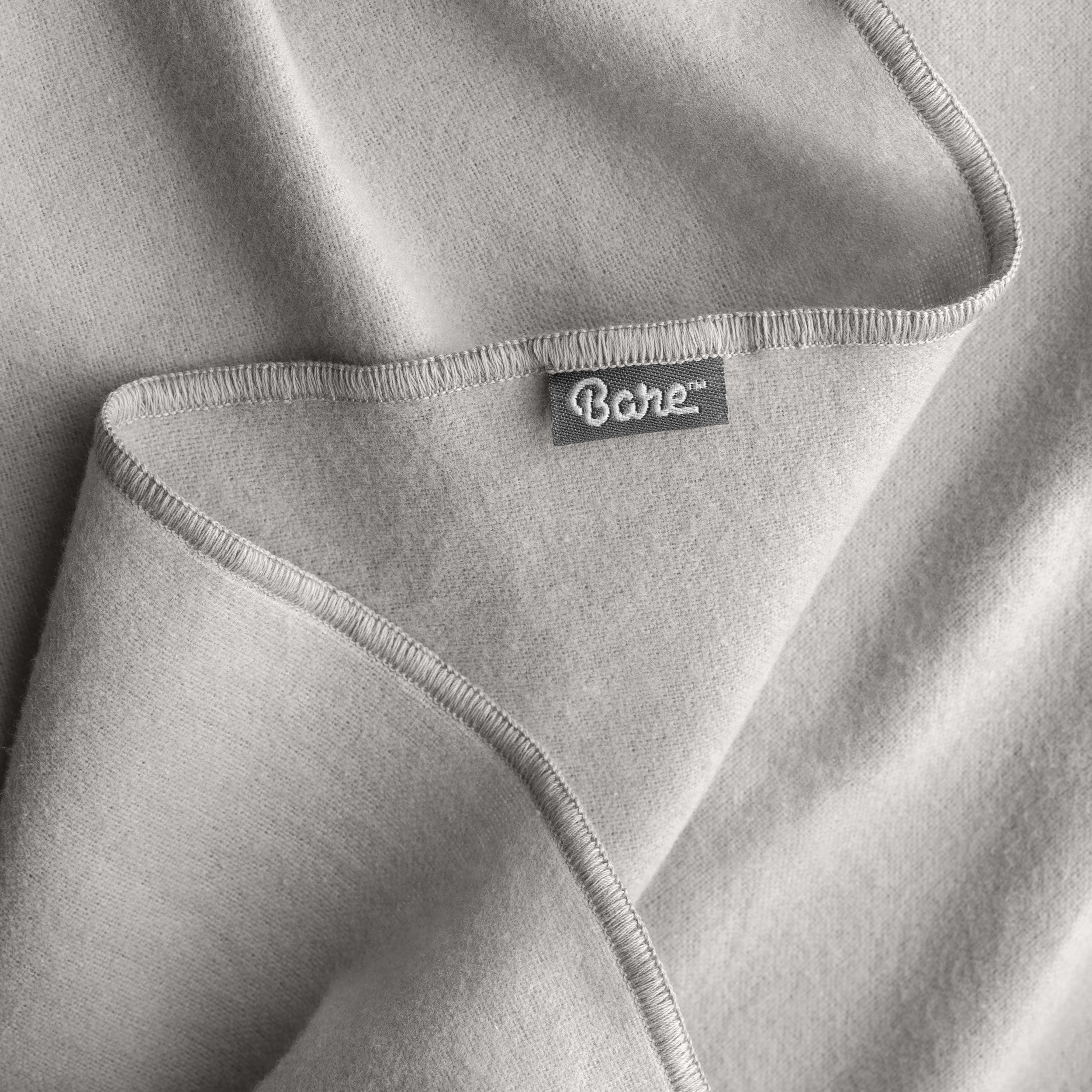 Up close image flannel receiving blanket light grey showing tag