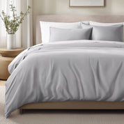 Bed with sateen bedding and pillows in a bedroom setting