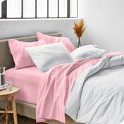 Sheets and a duvet cover on a bed in a bright bedroom