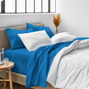 Sheets and a duvet cover on a bed in a bright bedroom
