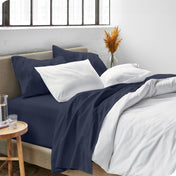 Sheets and a duvet cover on a bed in a bright bedroom