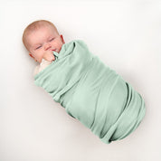 Baby wrapped in flannel receiving blanket
