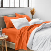 Sheets and a duvet cover on a bed in a bright bedroom