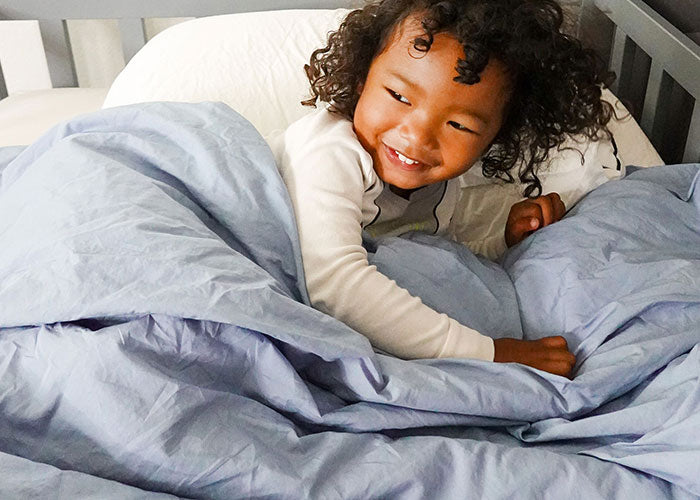 Little girl laying on light blue comforter