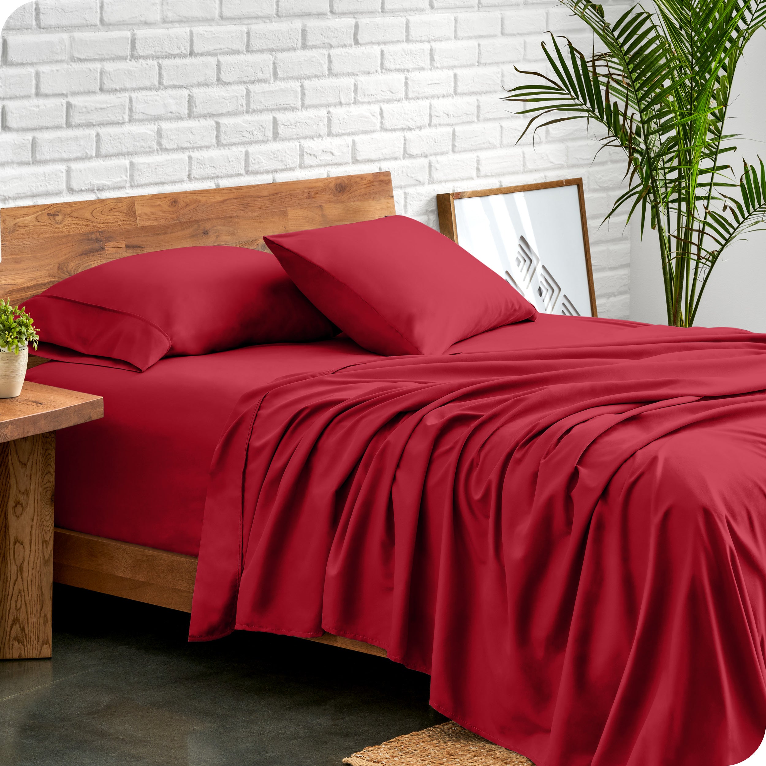Bed with microfiber sheets against a white brick wall