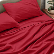 Sheet set on a bed with pillows and a plant in the background