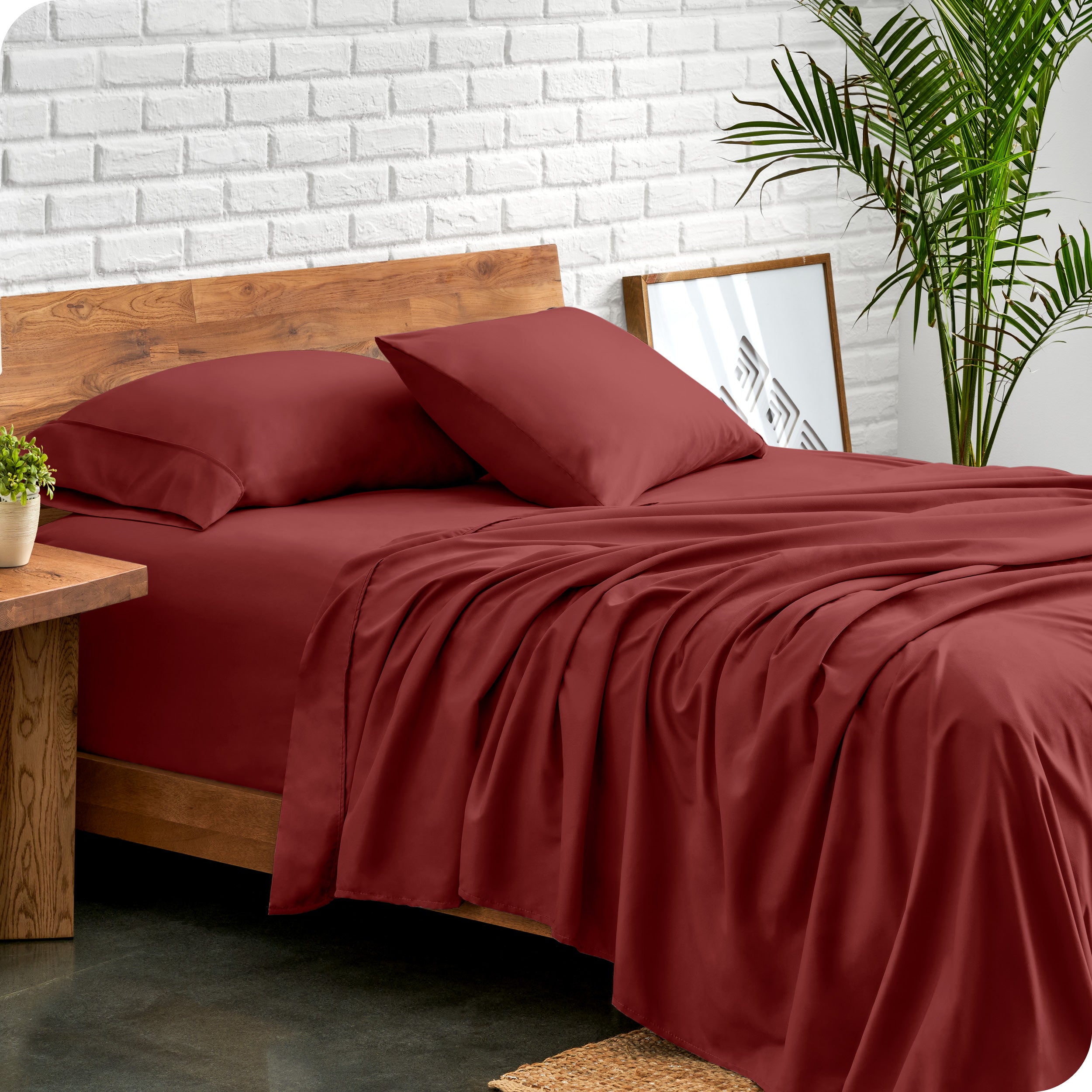 Bed with microfiber sheets against a white brick wall