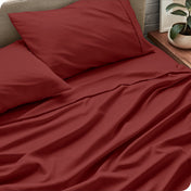 Sheet set on a bed with pillows and a plant in the background