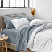 Sheets and a duvet cover on a bed in a bright bedroom