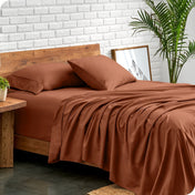 Bed with microfiber sheets against a white brick wall