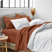 Sheets and a duvet cover on a bed in a bright bedroom