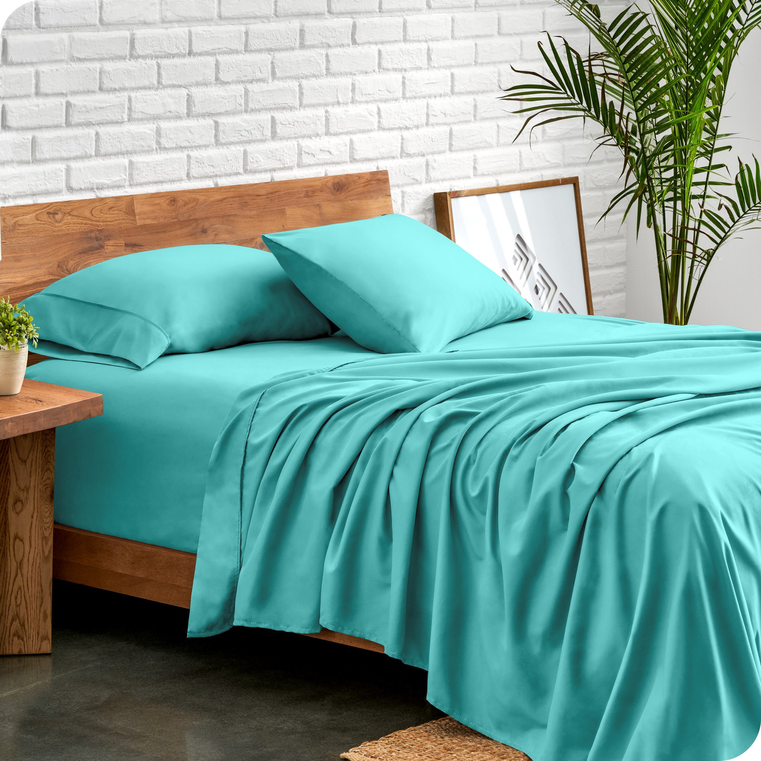 Bed with microfiber sheets against a white brick wall