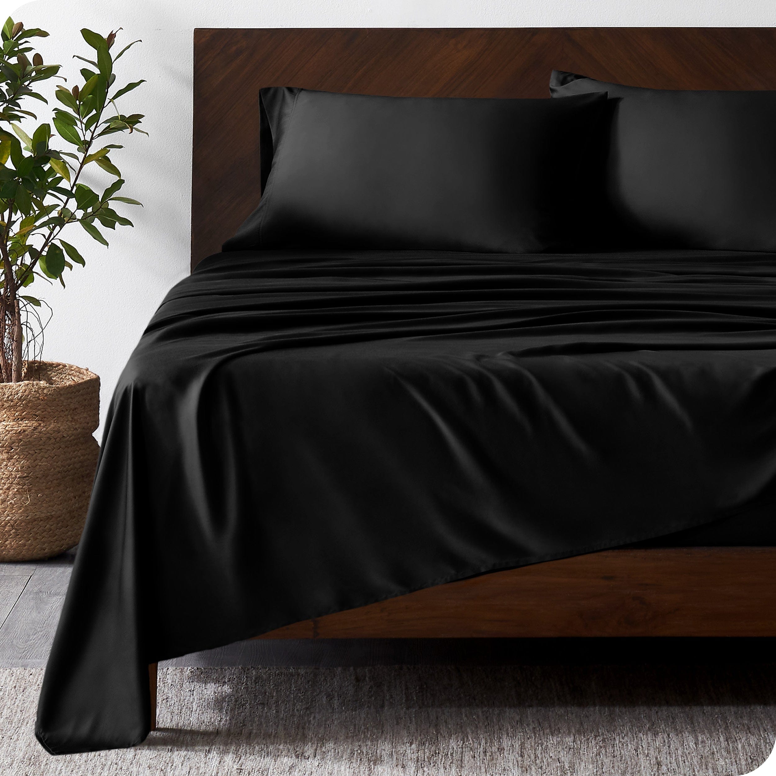 Wooded bed frame with bamboo sheets on the bed