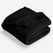 Black polar fleece blanket folded with 1 corner folded back