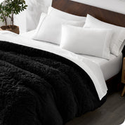 A modern bedroom with a shaggy duvet cover on the bed.