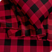 Close up of a pillowcase, top sheet and fitted sheet which are all matching plaid