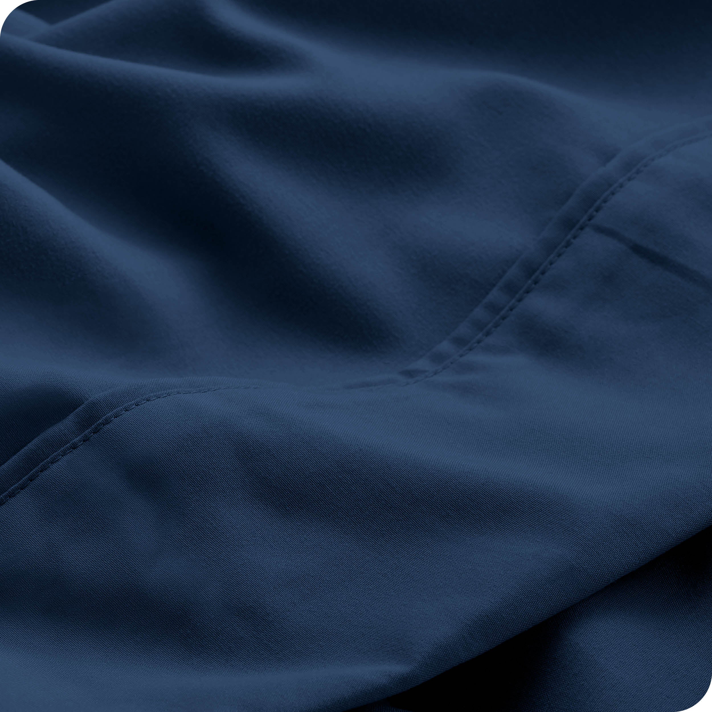 Close up of a dark blue microfiber sheet showing the stitching and texture
