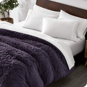 A modern bedroom with a shaggy duvet cover on the bed.