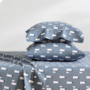 Flannel pillowcase with pillow inside stacked on a bed made with matching flannel sheets