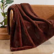 Faux fur blanket draped over a brown couch