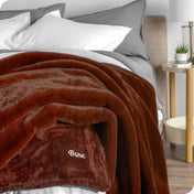 Faux fur blanket draped over the corner of a bed