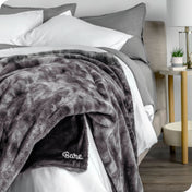 Faux fur blanket draped over the corner of a bed