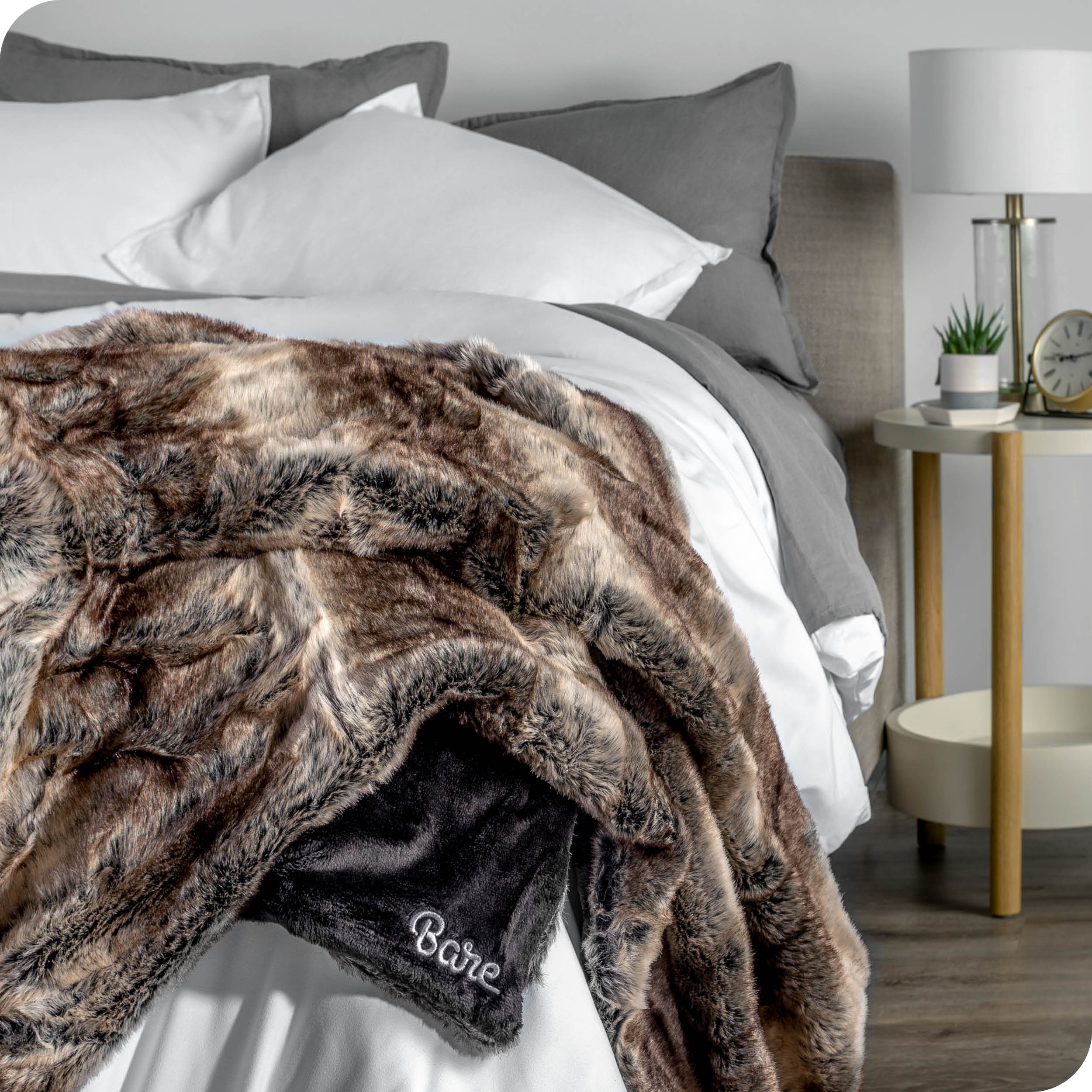 Faux fur blanket draped over the corner of a bed