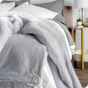 Faux fur blanket draped over the corner of a bed