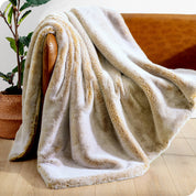 Faux fur blanket draped over a brown couch