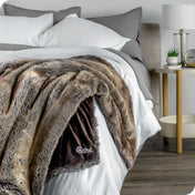 Faux fur blanket draped over the corner of a bed