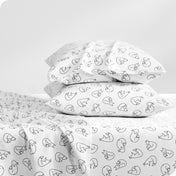 Flannel pillowcase with pillow inside stacked on a bed made with matching flannel sheets