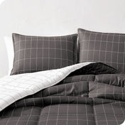 Close up of a comforter and pillow shams on a bed