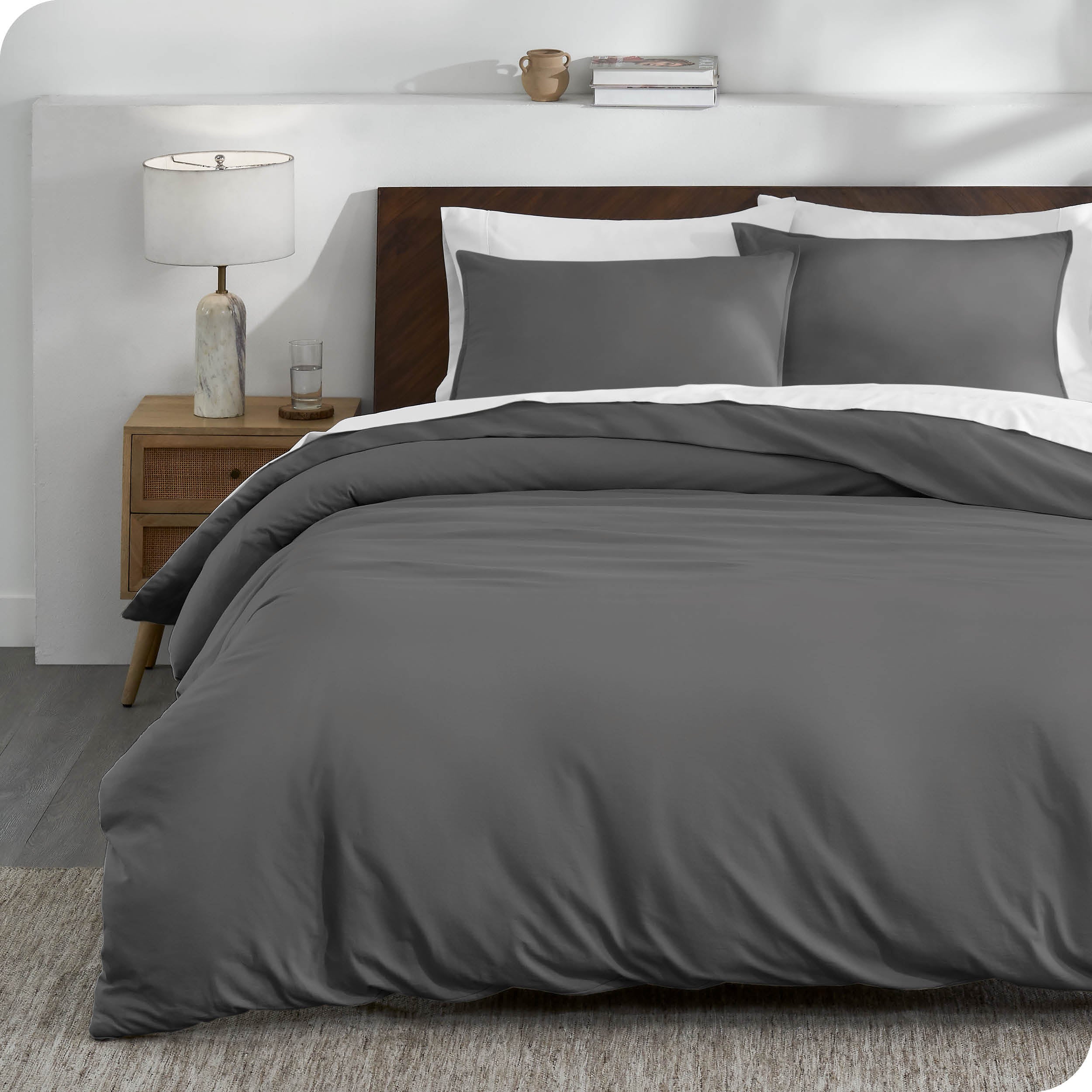 A grey organic cotton jersey duvet cover on a bed made with a white bedding