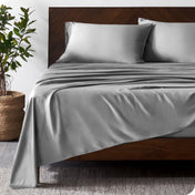 Wooded bed frame with bamboo sheets on the bed