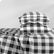 A side view of two pillows stacked on a bed with a microfiber printed set