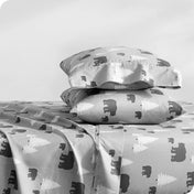 A side view of two pillows stacked on a bed with a microfiber printed set