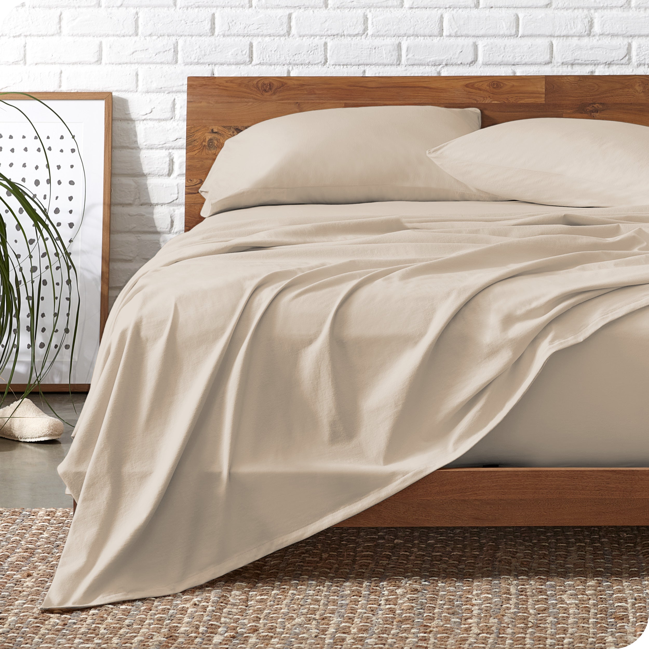 Wooden bed frame with sand organic cotton jersey sheets on the bed