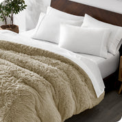 A modern bedroom with a shaggy duvet cover on the bed.
