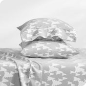 Flannel pillowcase with pillow inside stacked on a bed made with matching flannel sheets