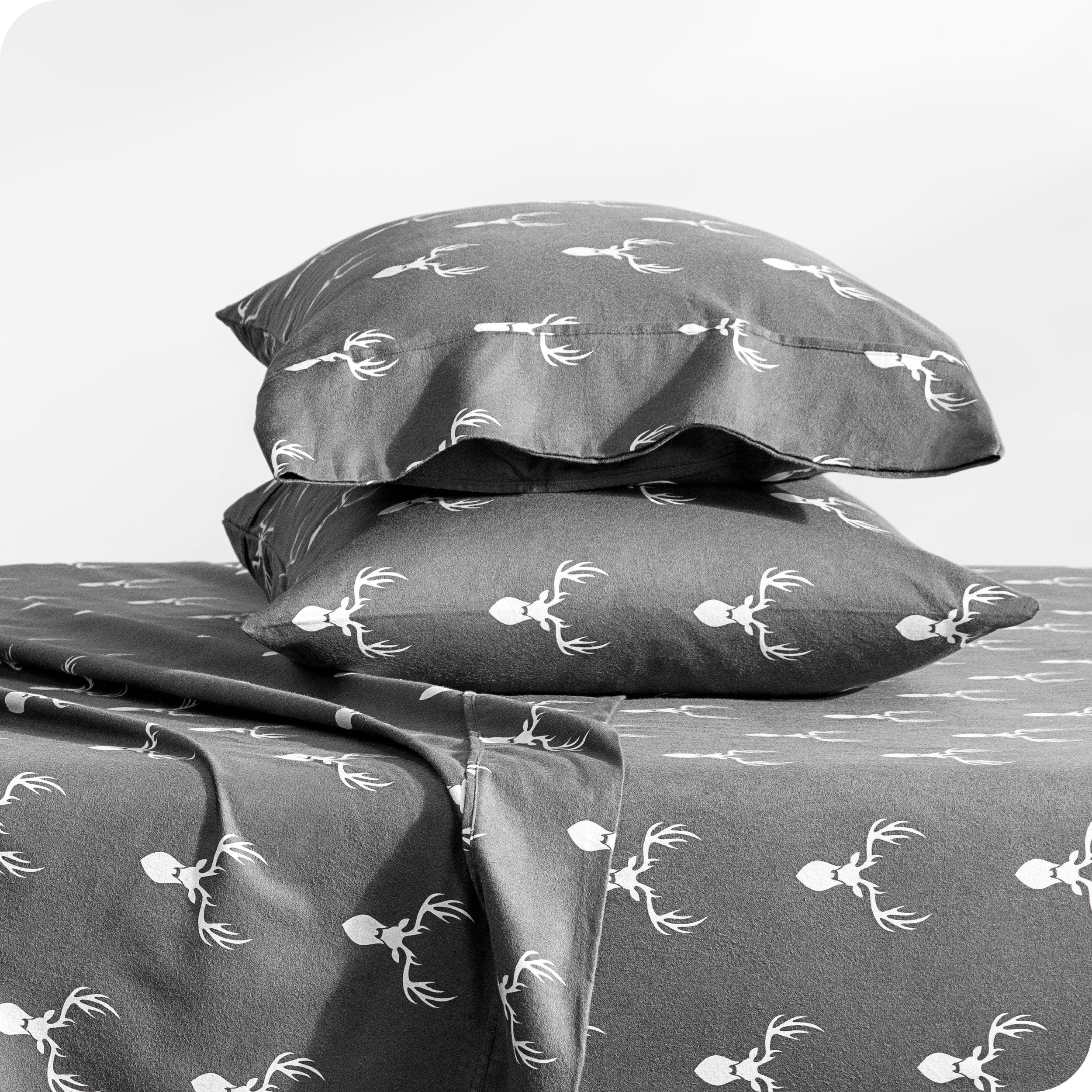 Flannel pillowcase with pillow inside stacked on a bed made with matching flannel sheets