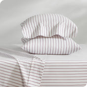 Flannel pillowcase with pillow inside stacked on a bed made with matching flannel sheets