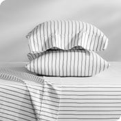 Flannel pillowcase with pillow inside stacked on a bed made with matching flannel sheets