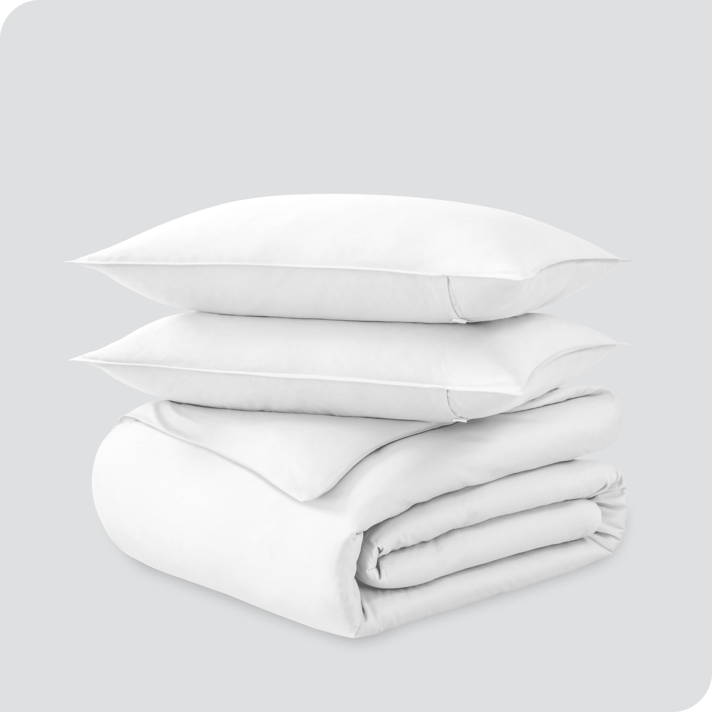 A folded organic sateen duvet cover with two pillows on top.