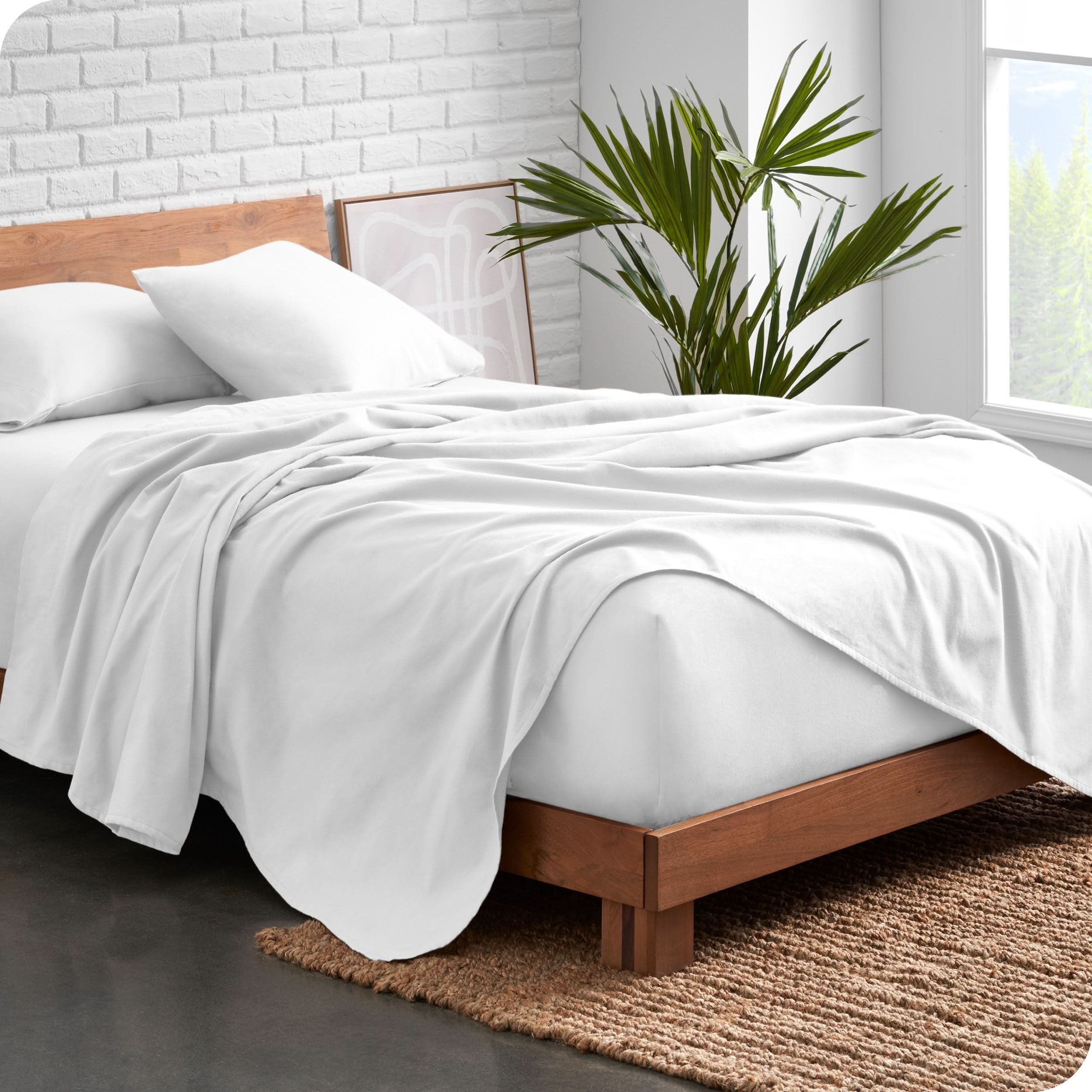 Modern wood bed frame with white organic flannel sheets and pillowcases