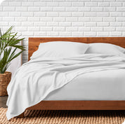 Modern wood bed frame with white organic flannel sheets and pillowcases